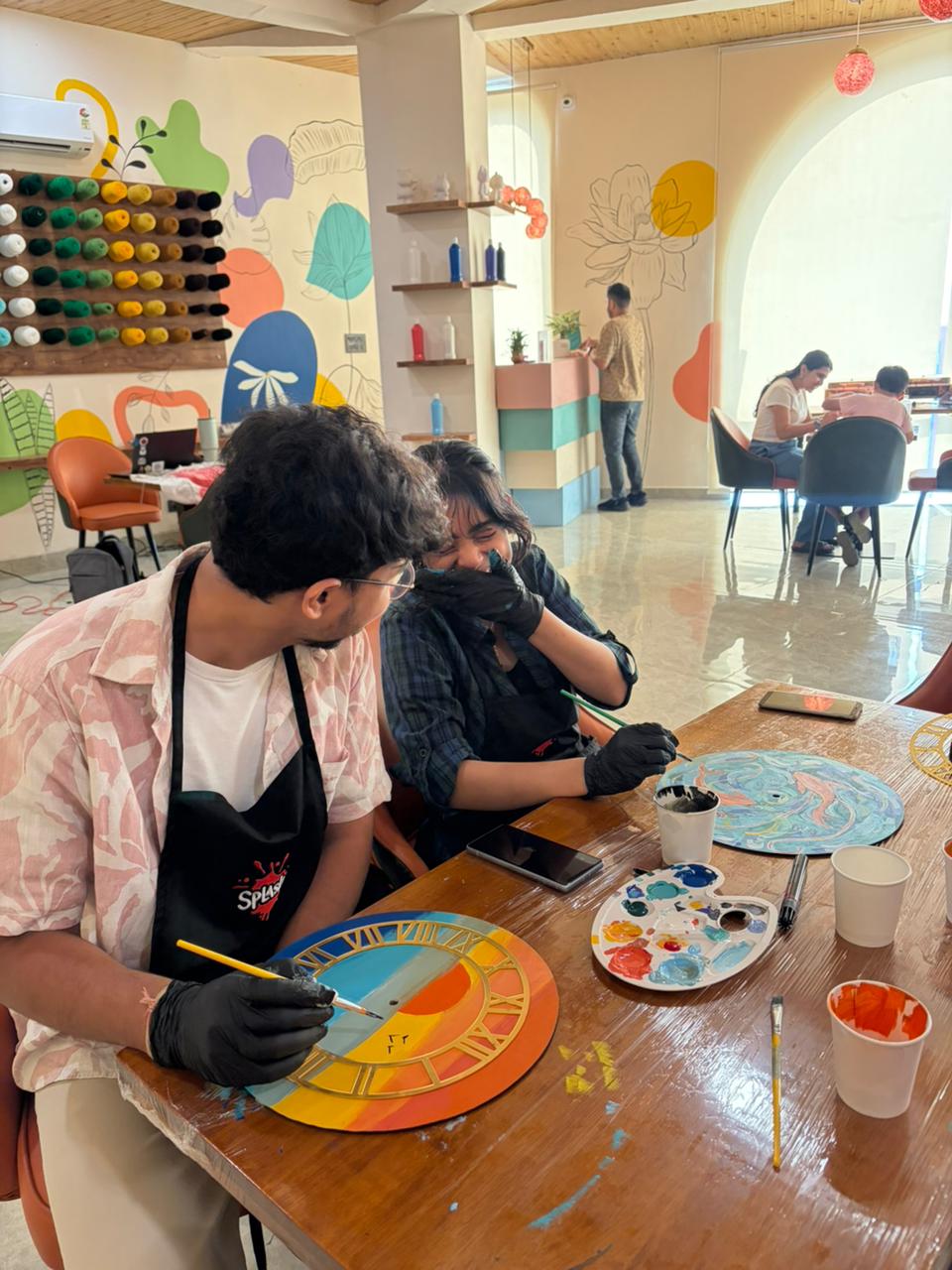 Couple painting together on a date day at Splashit